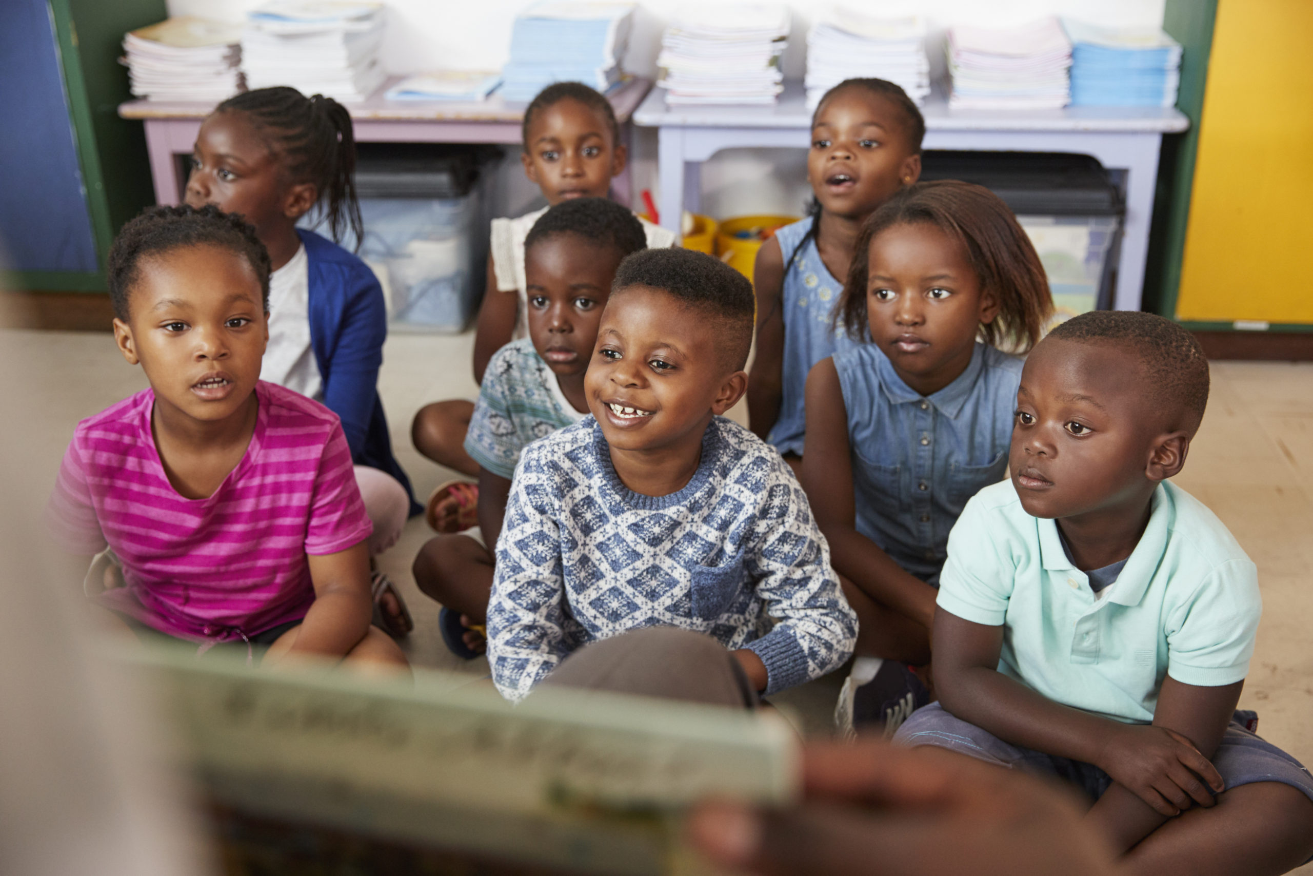 Teacher reading book to elementary school children in class